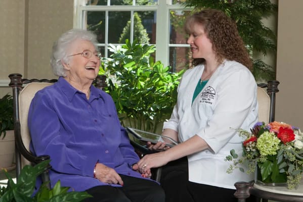 A caregiver interacting with a resident in an interior space