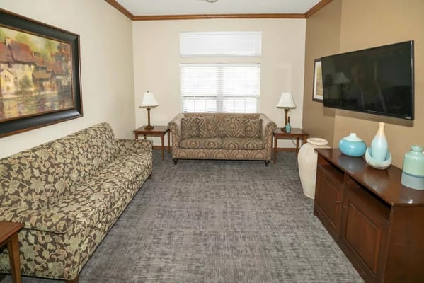 Cozy living room with two couches, lamps, and a television.