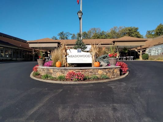 Entrance of Meadowood senior living facility with colorful flowers and a sign