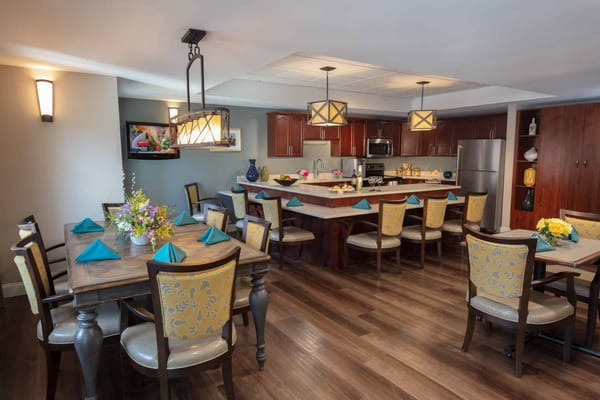Cozy dining area with floral centerpieces and teal napkins.