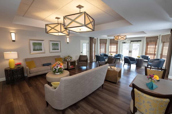 Cozy living room with seating and floral arrangements.