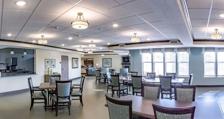 Bright and spacious common area with dining tables and a kitchenette