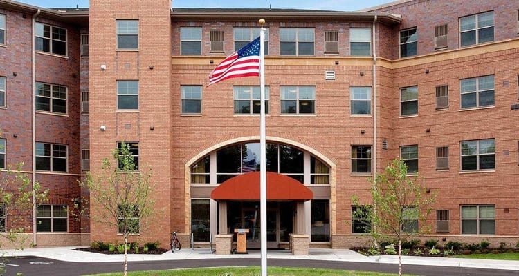 Entrance to Minnehaha Senior Living with American flag and landscaped walkway