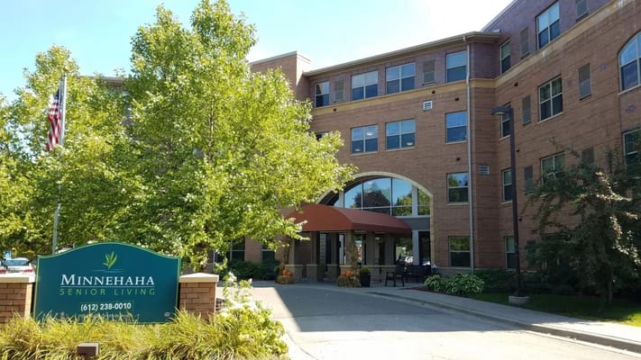 Main entrance of Minnehaha Senior Living facility with greenery and a sign