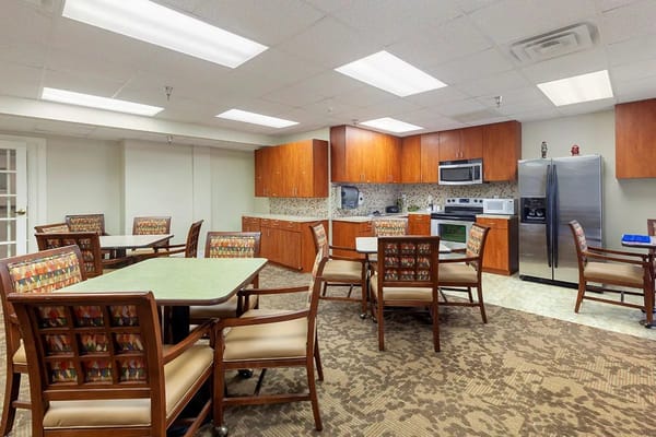 Common area with dining tables and kitchen appliances