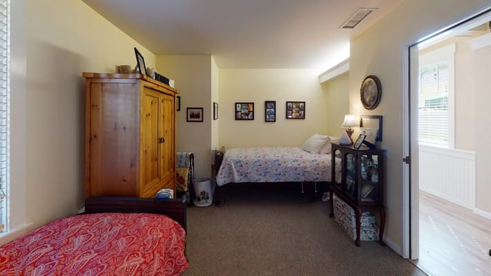 Interior view of a cozy bedroom with two beds and a wooden wardrobe.