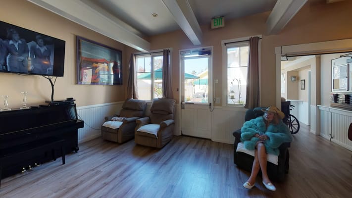 Indoor lounge with comfortable seating, television, and views of the outdoors