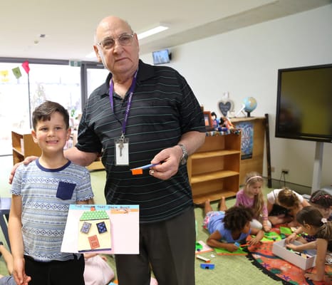A senior and a child engaging in an activity in a bright common area.