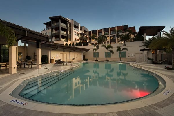 Outdoor pool area with lounge chairs and building in background