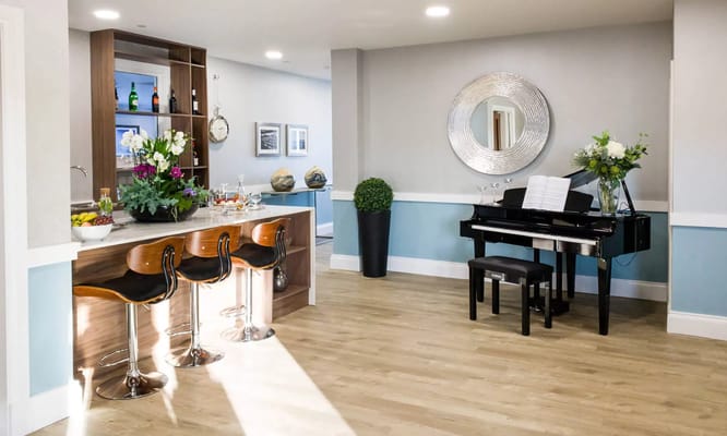 Bright common area with piano and bar seating