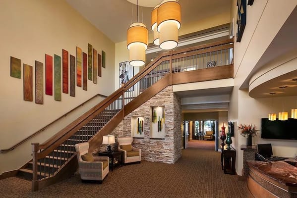 Spacious lobby with staircase and decorative wall art