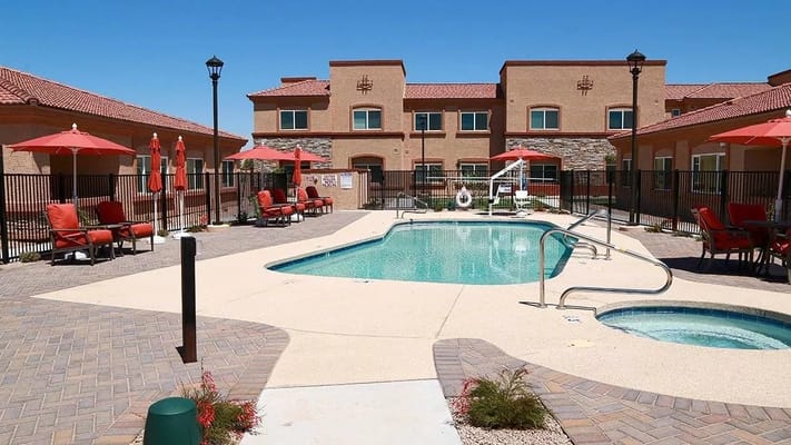 Outdoor pool area with seating and umbrellas