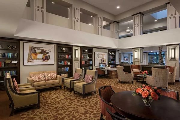 Common area with seating and bookshelves in a senior living facility