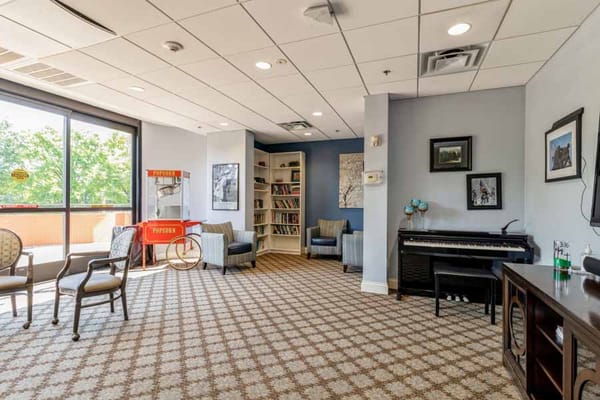 Cozy lounge area with seating, bookshelf, and a popcorn machine