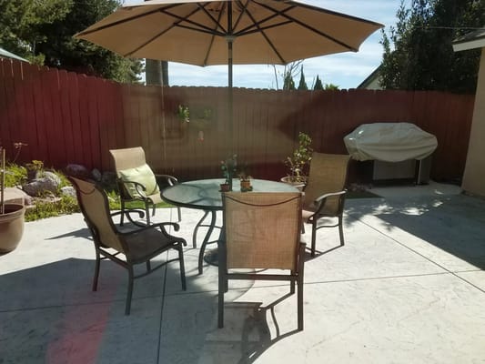 Outdoor patio with a table and chairs under an umbrella