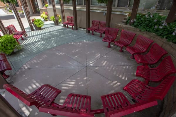 Outdoor seating area with red benches and greenery