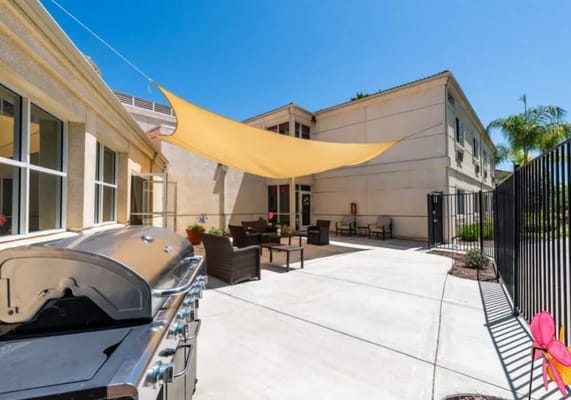 Outdoor patio area with seating and grill