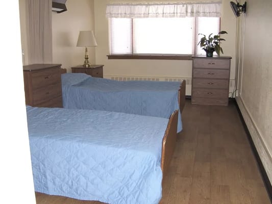 A shared resident room with two beds and furniture