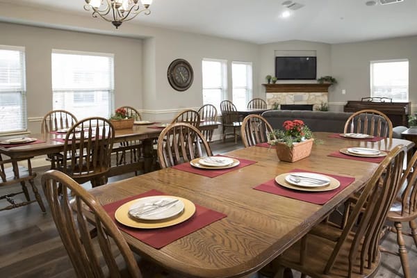 Cozy dining area with wooden tables and chairs, set for a meal.