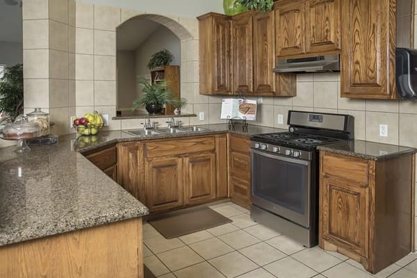 A modern kitchen with wooden cabinets and granite countertops.