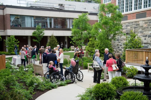 Residents and guests enjoying a social event in the garden area.