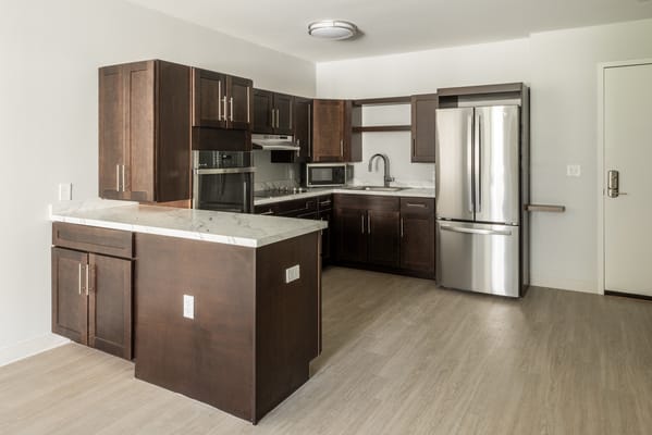 Spacious kitchen with dark cabinets and modern appliances
