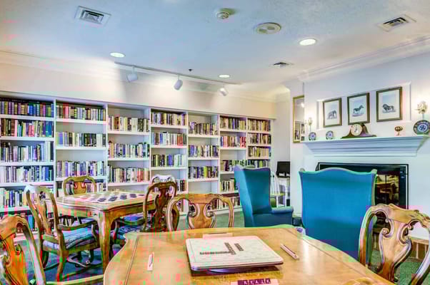 Cozy library with bookshelves and game tables at Newhaven Court
