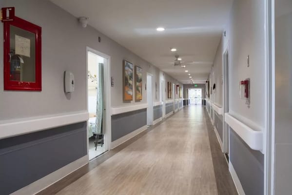 Brightly lit hallway with artwork and resident rooms