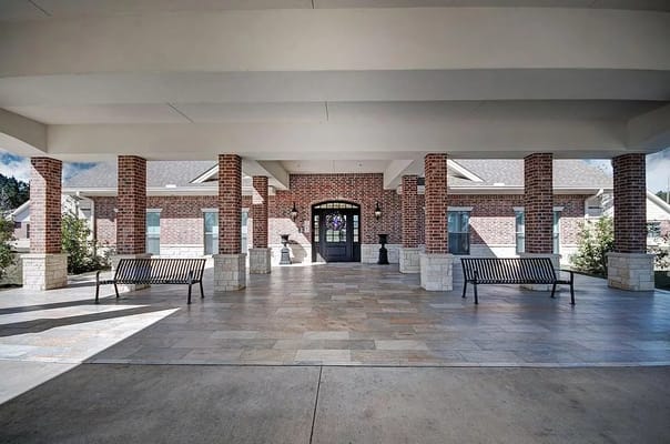 Covered entrance area with benches and brick columns