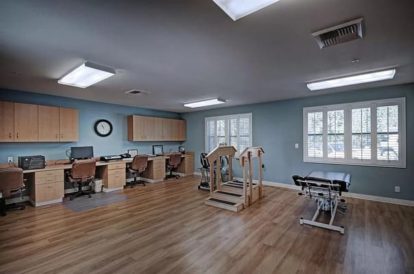 Therapy room with rehabilitation equipment and workstations.