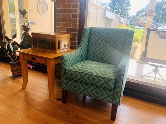 Cozy seating area with a patterned chair and radio