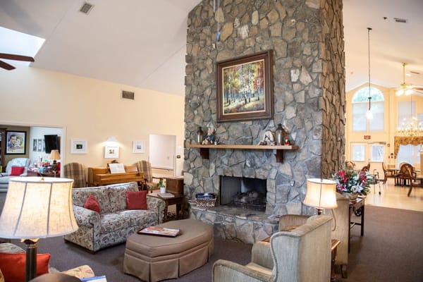 Cozy common area in a senior living facility with a stone fireplace