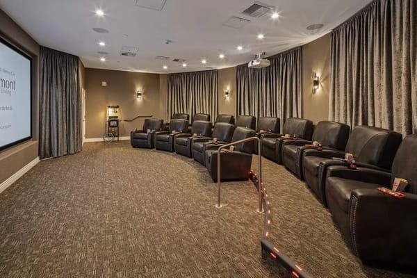 Cozy movie theater with recliner seating for residents