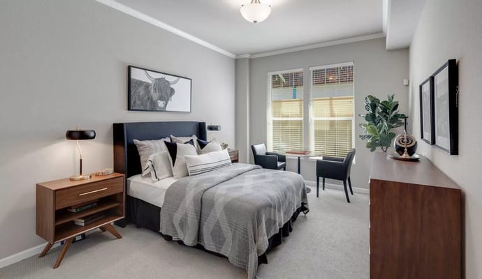 Stylishly decorated bedroom with a bed, nightstand, and desk