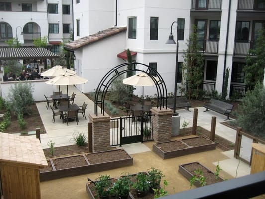 Outdoor patio area with seating and garden beds