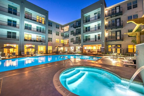 Illuminated swimming pool and hot tub area at Overture Plano