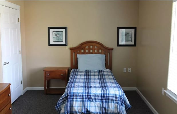 A private resident room with a bed and wall art