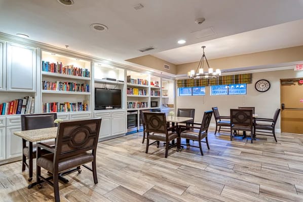Common area with bookshelves and seating in a warm atmosphere