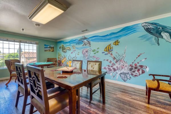 Brightly decorated game room featuring an underwater-themed mural.