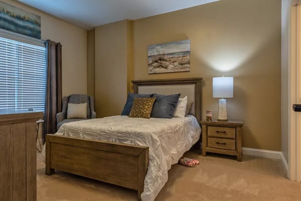 A cozy resident room with a bed and armchair