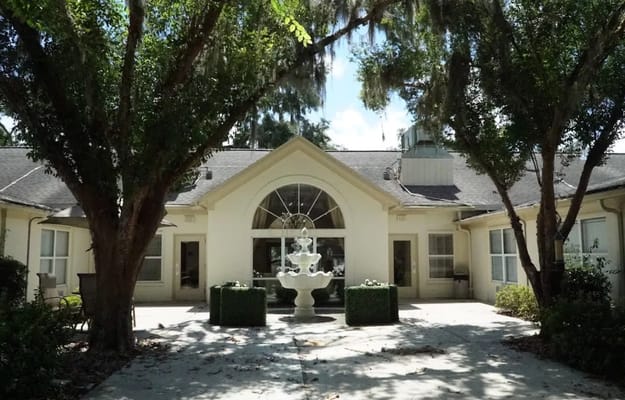 Exterior view of a senior living facility with a fountain