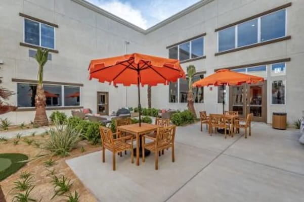 Outdoor seating area with orange umbrellas and tables