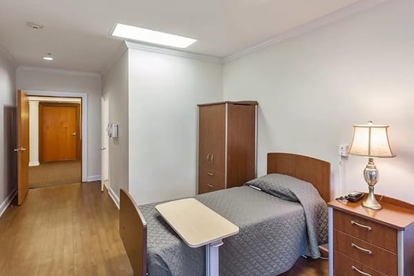 Interior view of a cozy bedroom with a single bed and wooden furniture