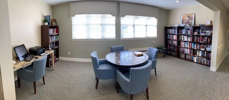 A cozy common area with bookshelves and a table