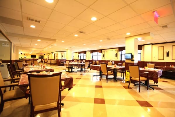 Spacious dining area with tables set for residents.