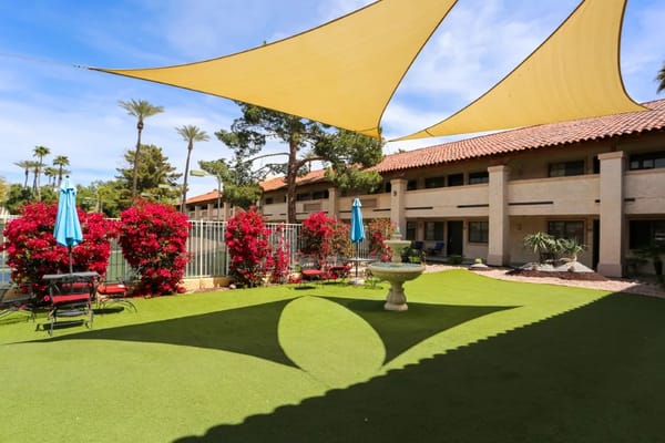 Lush courtyard with vibrant flowers and shaded seating areas