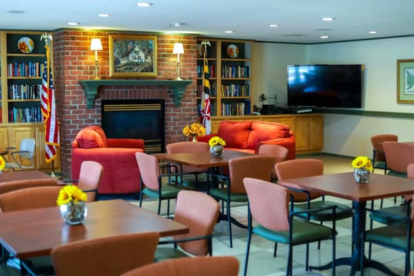 Cozy common area with red sofas, a fireplace, and bookshelves