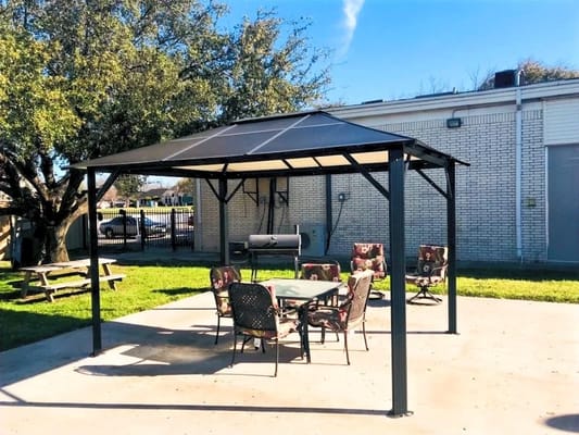 Outdoor gazebo area with seating and picnic table