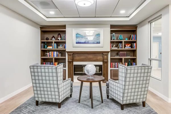 Living room with two armchairs, coffee table, and bookshelf