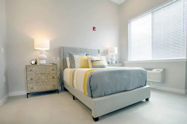 A well-decorated bedroom with a bed and bedside table.